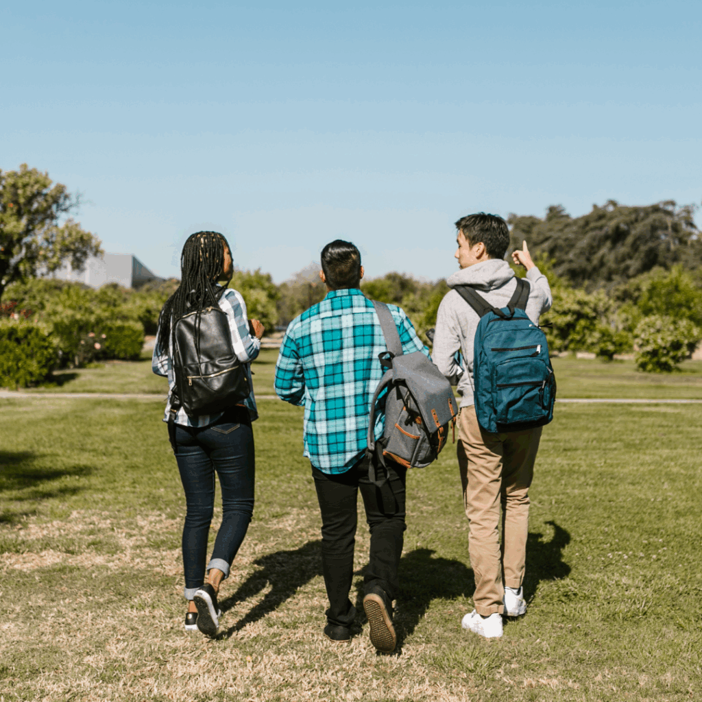 Three students walking on college campus.